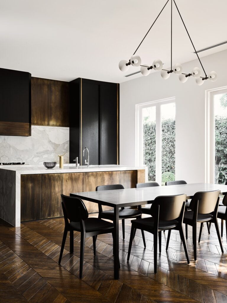 Contemporary kitchen featuring wooden floors and black cabinets.