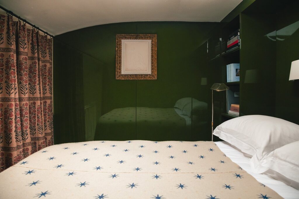 Dark green bedroom with white bed and red curtains