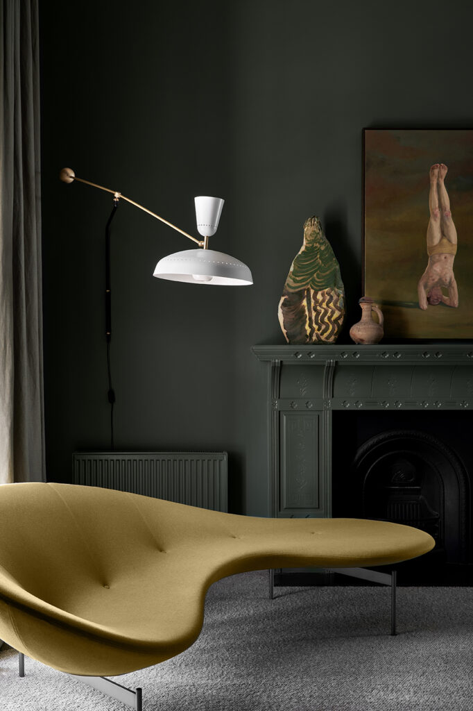 Simone Haag The Whiskey Room living room with green walls and with a fireplace and white a mustard couch