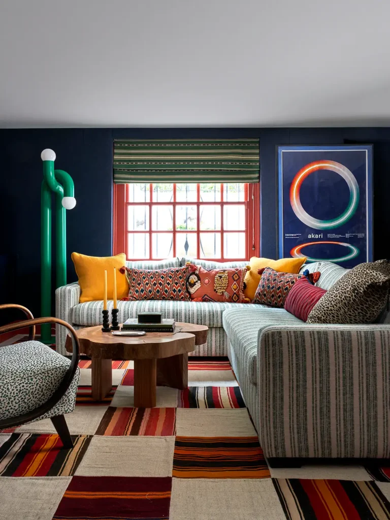 maximalist interior design living room with a large geometric sectional sofa and with a geometric rug and with a bold and green lampside