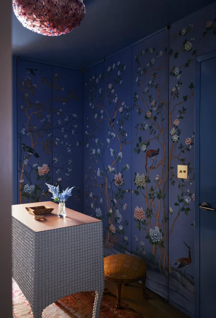 maximalist interior design dressing room with blue and flowery wallpaper and with a cabinet