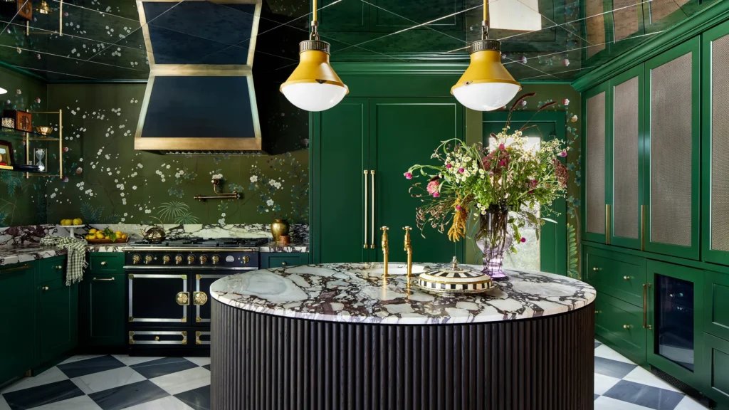 maximalist interior design with green and flowery wallpaper and with green cabinets and with a marble island