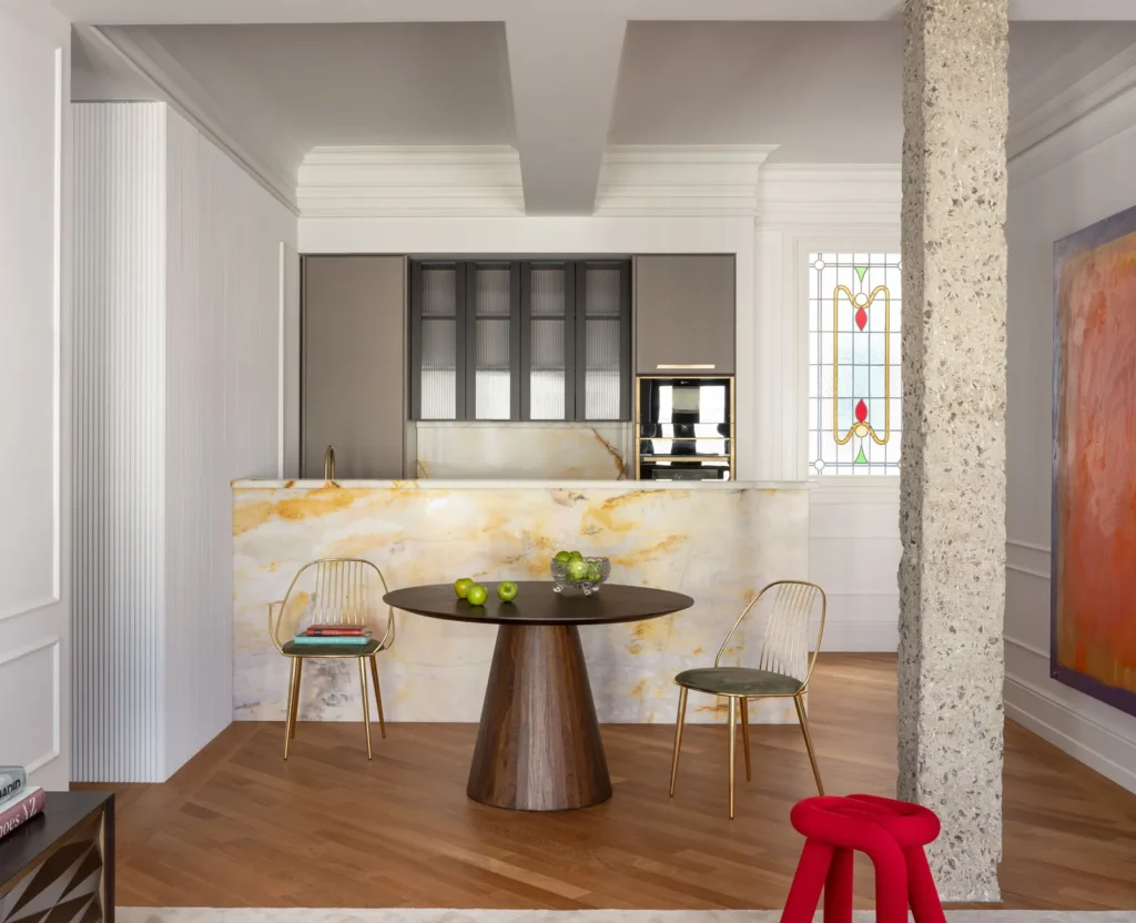 Contemporary Interior Design open space kitchen with a grey cabinet and with a marble peninsula and a wood round dining table and with decorative molding on the wall