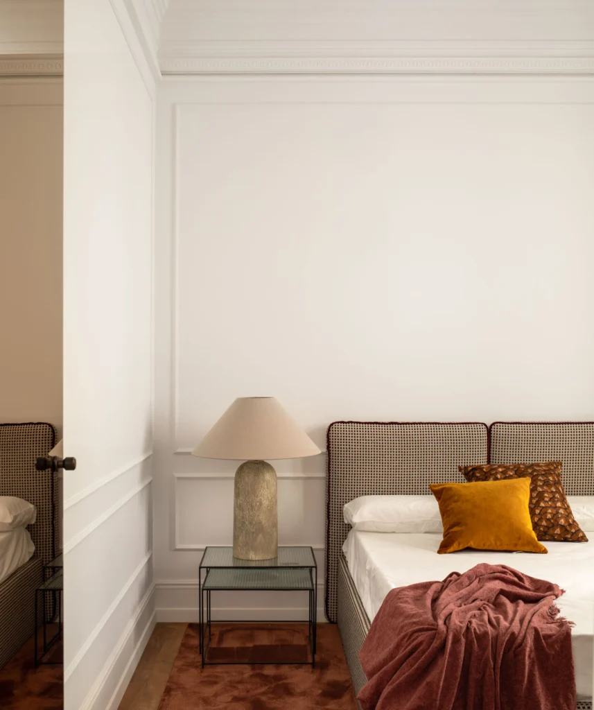 Contemporary Interior Design bedroom with a modern bed and a velvet headboard and with decorative molding on the wall