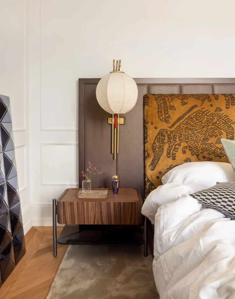 Contemporary Interior Design bedroom with a modern bed and a velvet yellow headboard and with decorative molding on the wall