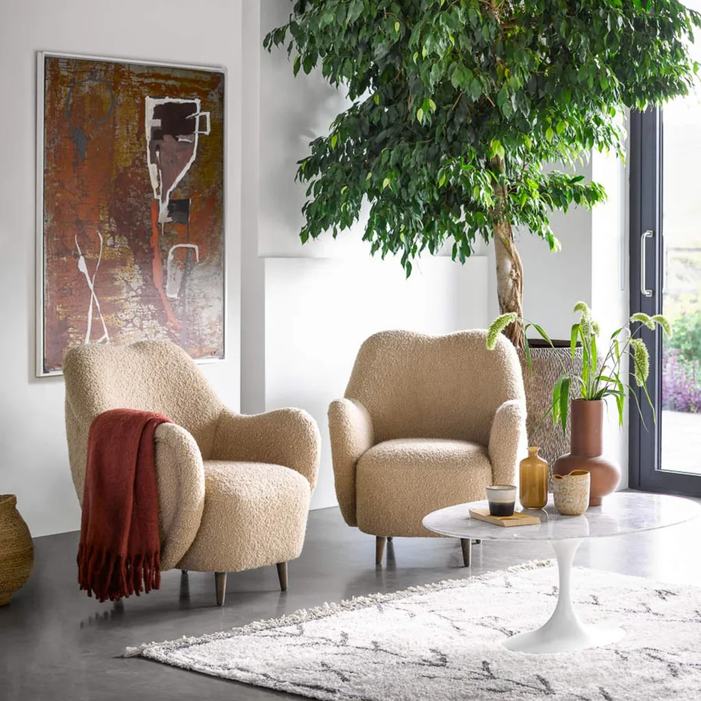 An organic modern living space, featuring cozy, rounded armchairs and natural decor elements that create a warm and inviting atmosphere.