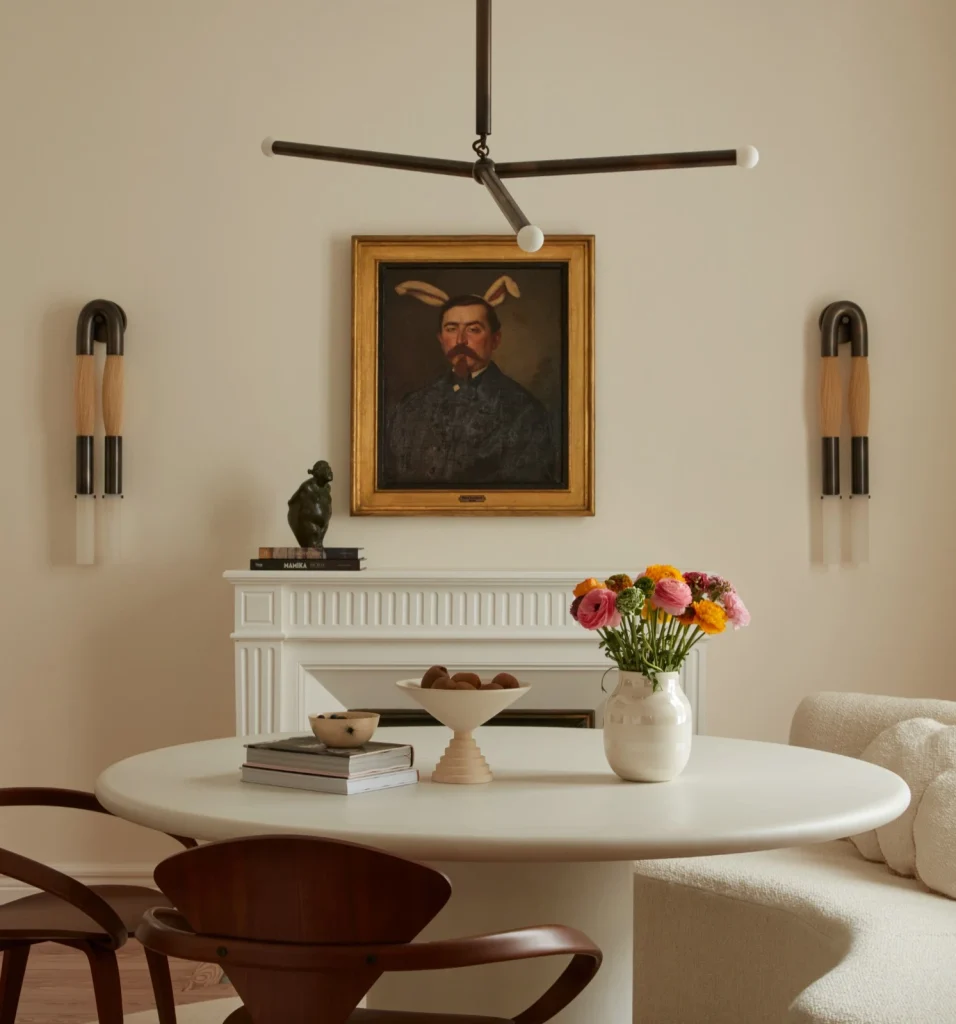 french villa dining room with cream walls and with a white fireplace and with a white round travertine table and with wooden chairs