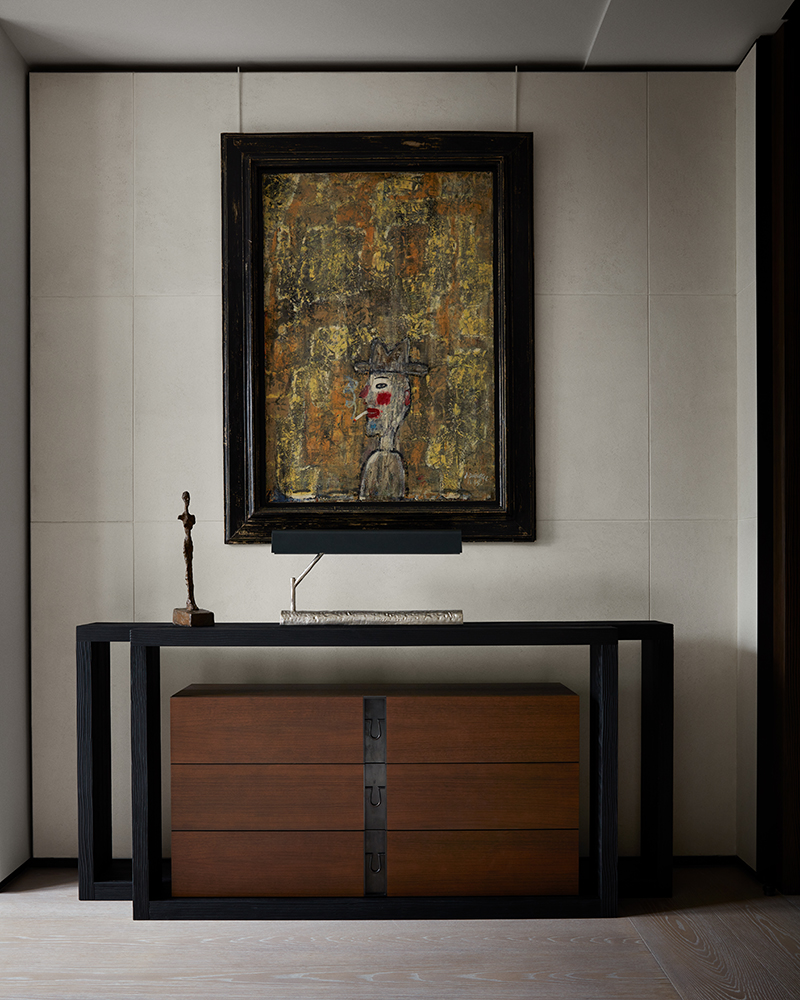 Luxury Interior Design hallway with cream walls and with a black and wood sideboard and with a canvas painting on the wall