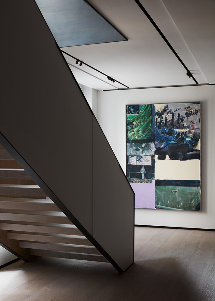 Luxury Interior Design hallway with cream walls and with a large staircase and with a big canvas painting on the wall