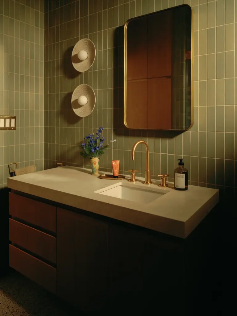 Mid-Century Modern house bathroom with green tiles and with a wood lavatory and with a rectangular mirror and with rounded lamps