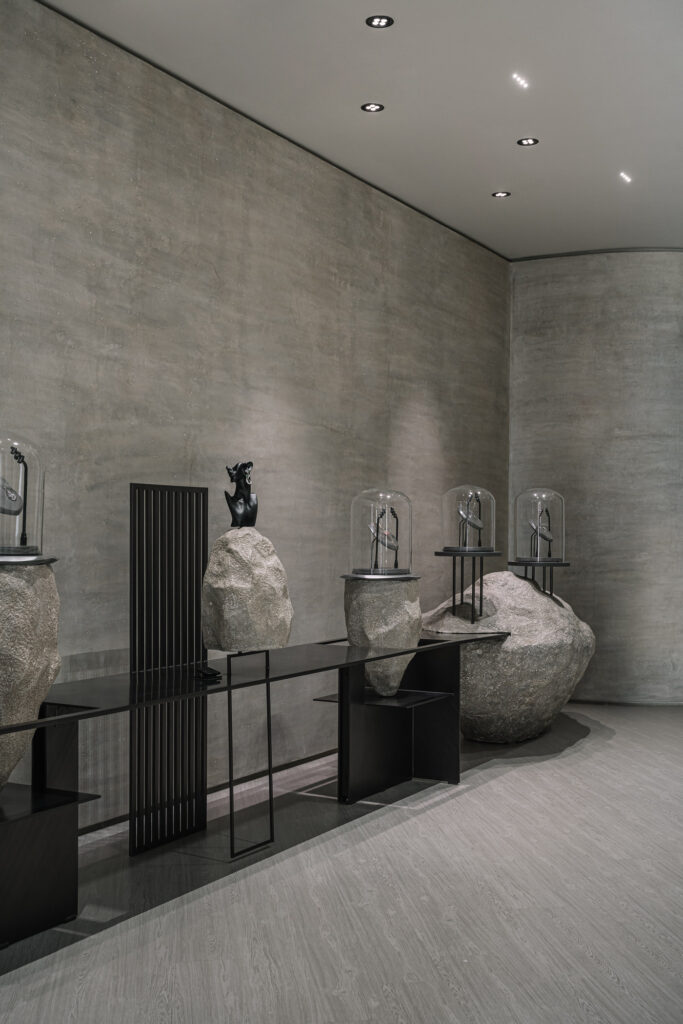 This display area showcases a striking blend of brutalist design, where rough-hewn stone elements are juxtaposed with sleek, minimalist structures.