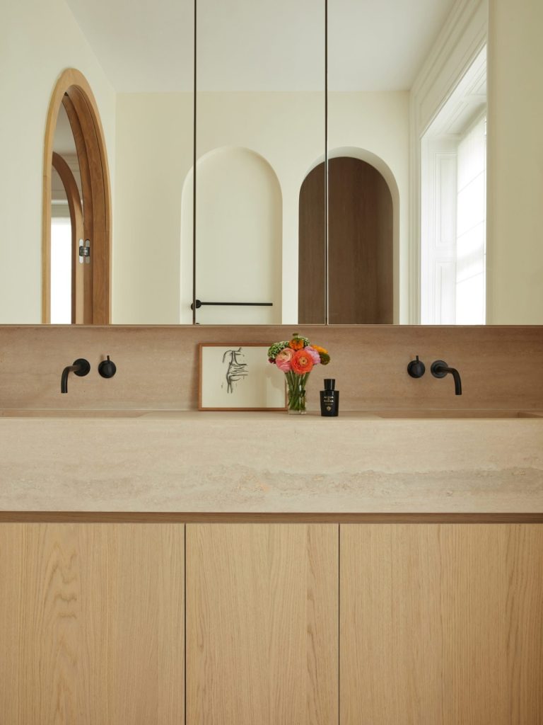 french villa bathroom with oak wooden cabinets and a large mirrow