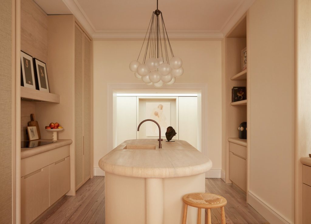 french villa kitchen with built-in cabinets and with a round travertine island and with wooden chairs