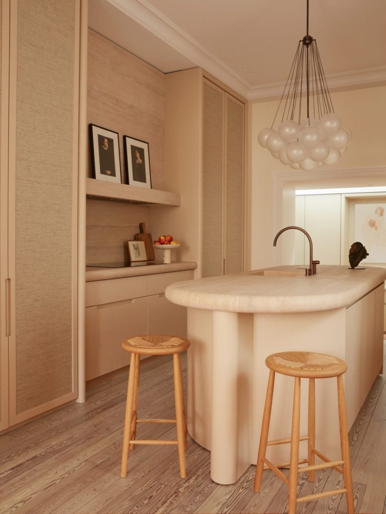 french villa kitchen with built-in cabinets and with a round travertine island and with wooden chairs