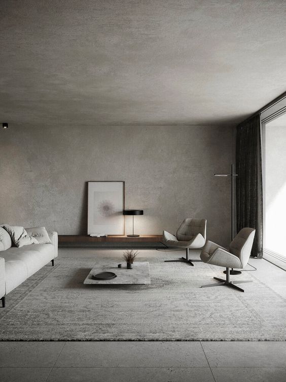 Raw Aesthetics in a brutalism architecture living room with concrete walls and floors and with a white sofa and with leather armchairs