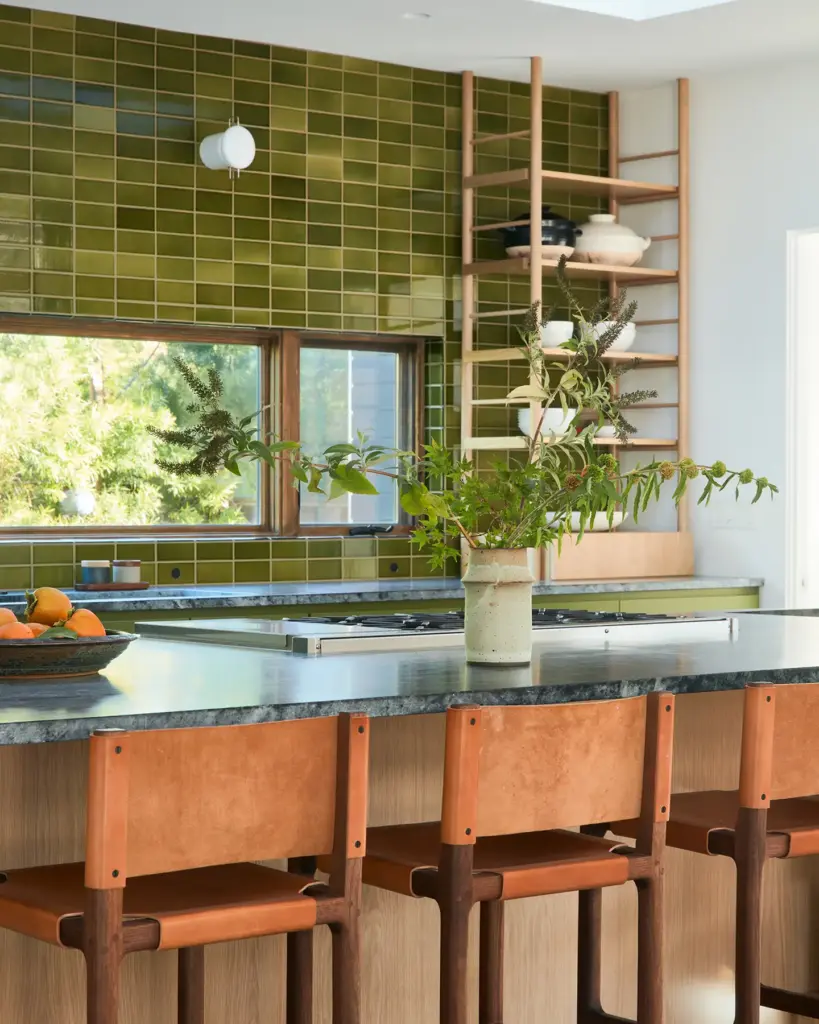 Organic Modernism style kitchen with green tiles and with a stone countertop and with leather kitchen stools