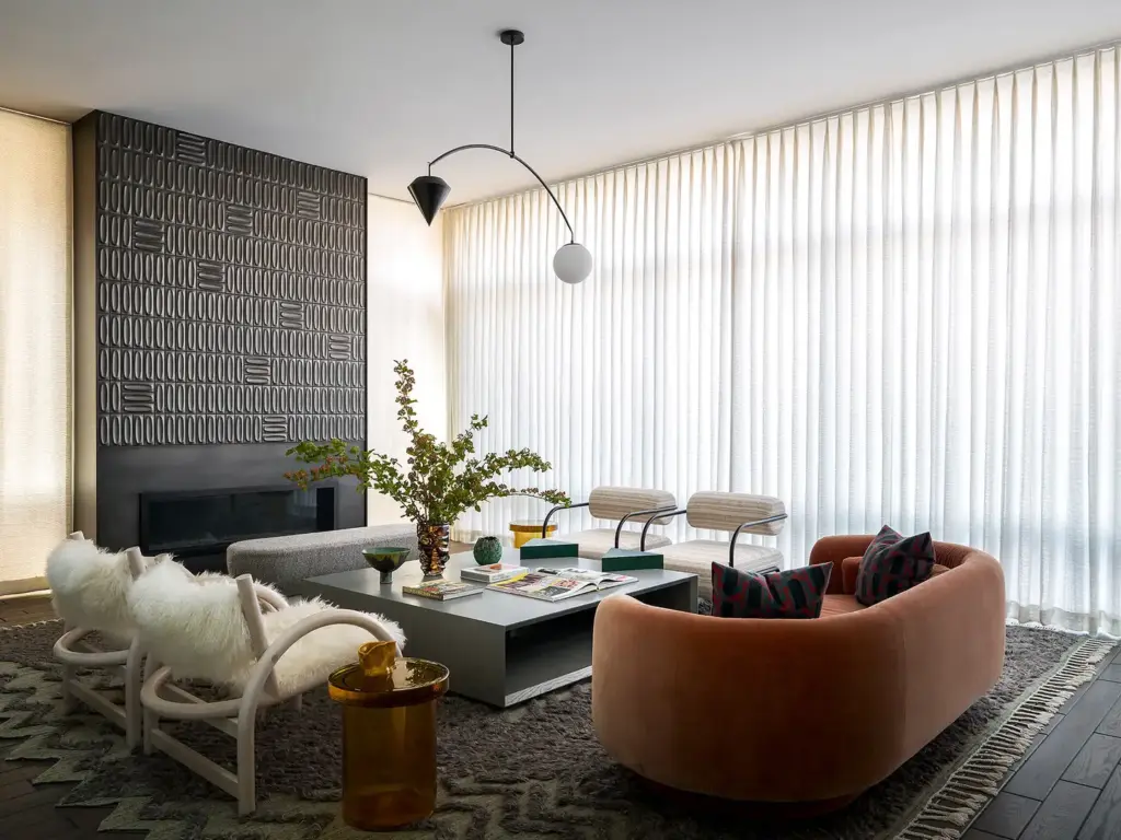 Organic Modernism style living room with large windows and with cream walls and with a large terracotta velvet sofa and with cream armchairs and with a large wood center table and with a large textured rug