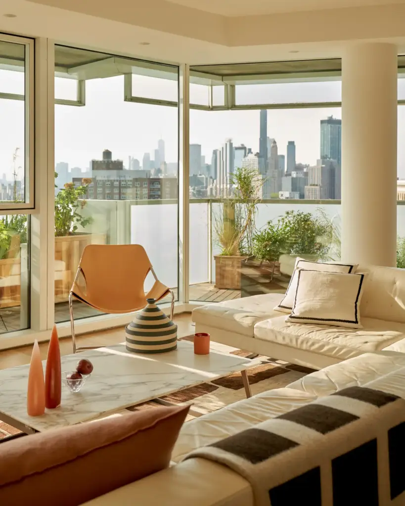 Organic Modernism style living room with large windows and with a panoramic view and with cream sofas and with a large center table and with a leather armchair