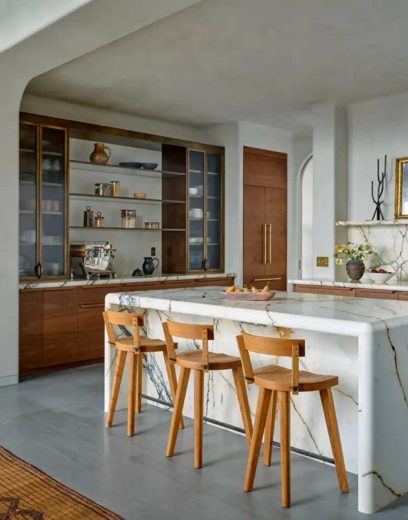 Organic Modernism style kitchen with a marble island and with wood stools and with wood cabinets