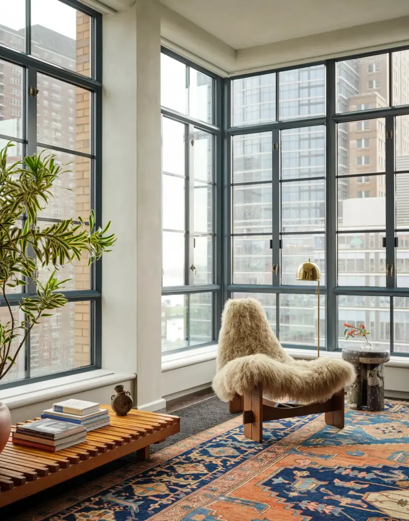 Organic Modernism style living room with large windows and with cream walls and with a accent armchair and with a large textured rug and with a wood bench