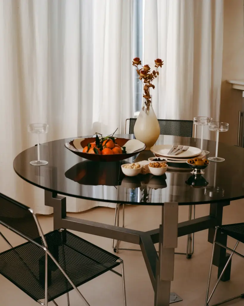 Apartment Renovation in Barcelona with beige walls and with cream floors and with cream curtains and with a dark glassed dining table