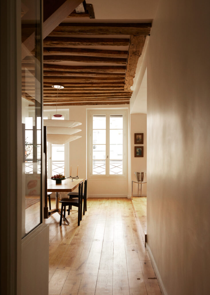 French interior design home with cream walls and with large windows and with wood exposed beams