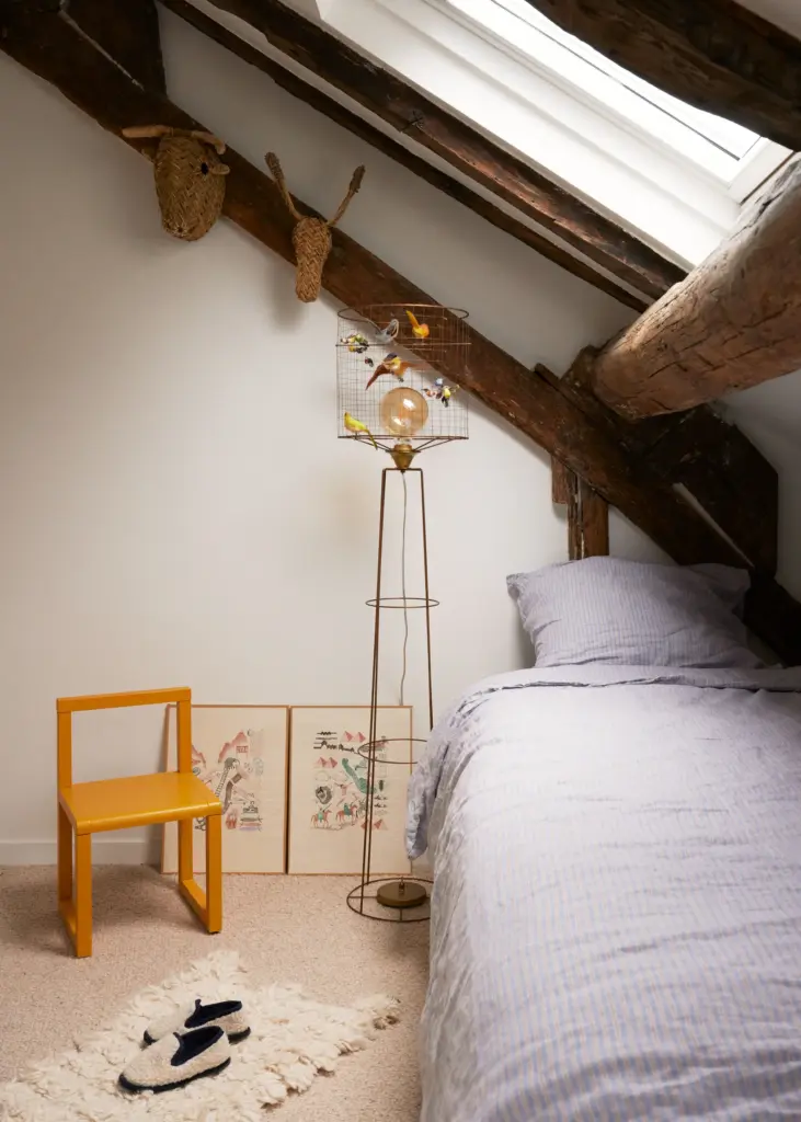 French interior design home kids bedroom with cream walls and large windows and wood exposed beams and small beds