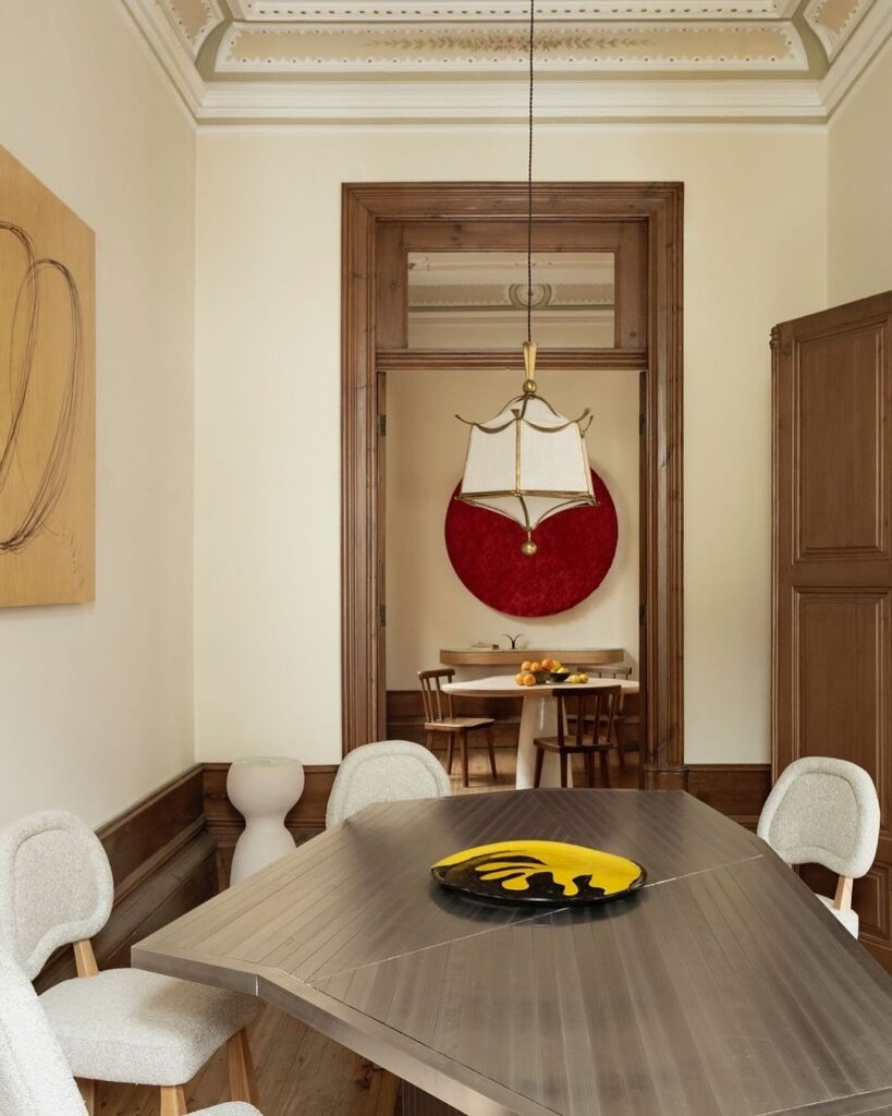 eclectic interior design dining room with cream walls and with a marble dining table and with classic dining chairs