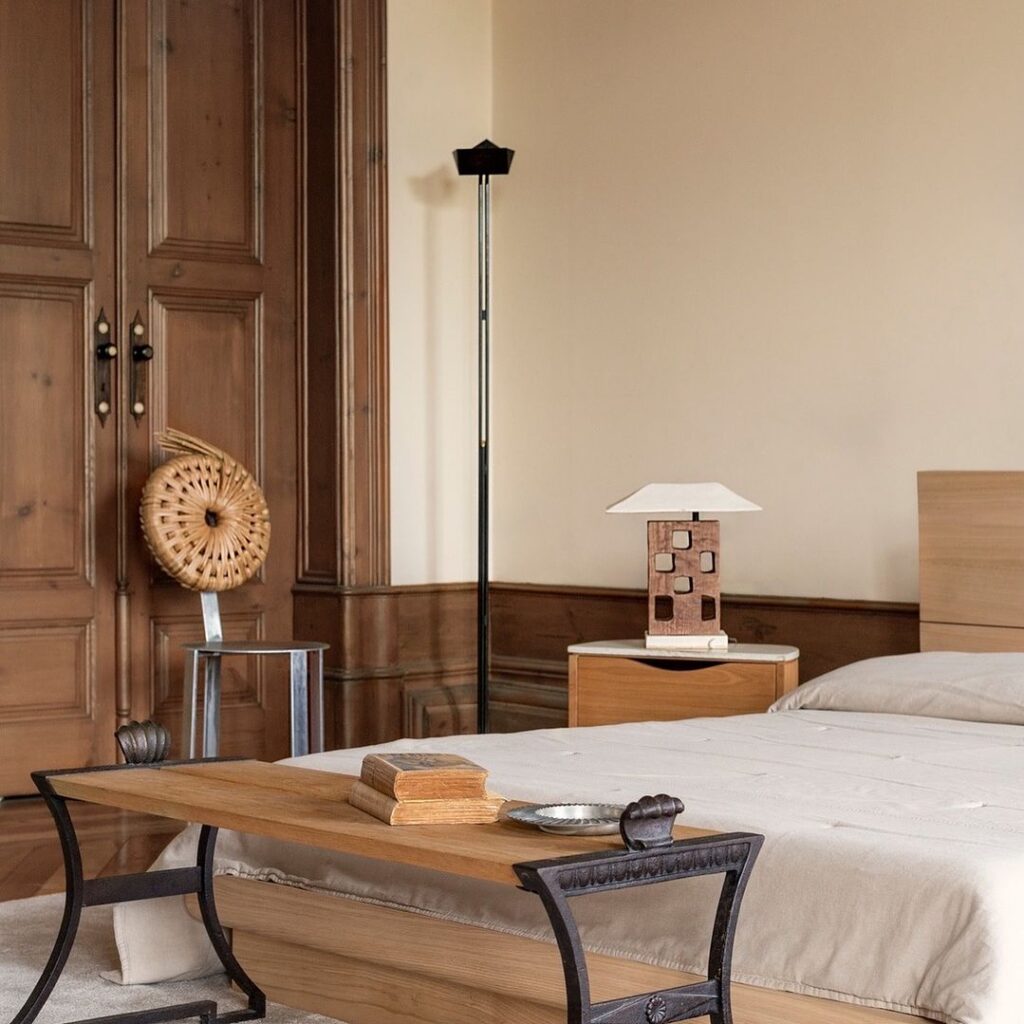 eclectic interior design bedroom with cream walls and with wooden doors and with a bench and with wooden bedside tables