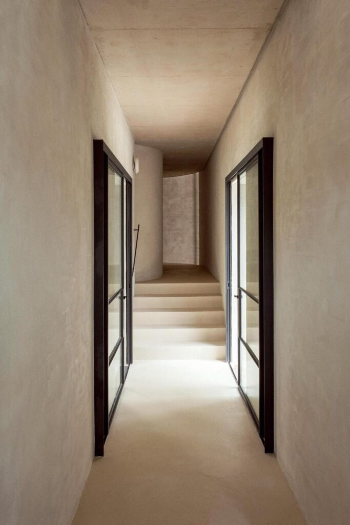 minimalist architecture hallway with cement walls and with black framed windows