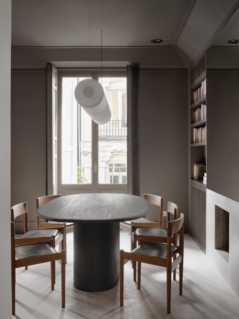 minimalist interior design dining room with grey walls and with a black dining table and with wood dining chairs