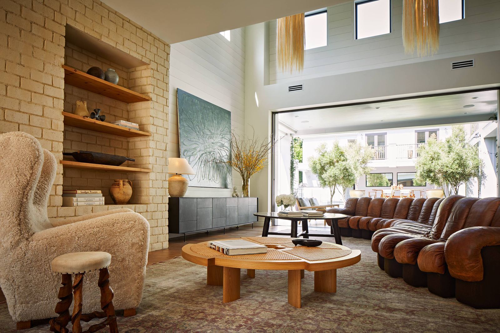 Modern Homes: A cozy and stylish living room with a fireplace and large windows.
