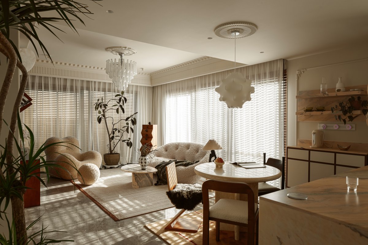 Sunlit, airy space showcases contemporary interior design with sculptural furniture, textured accents, and layered lighting. A harmonious blend of modern and classic elements.