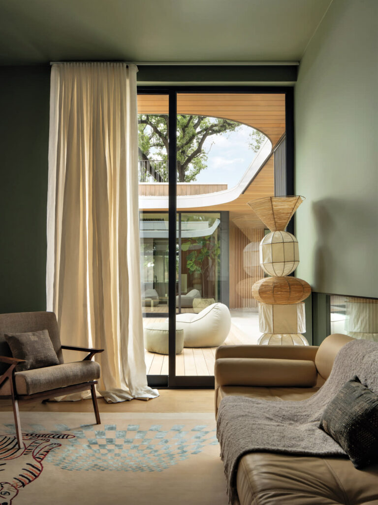 A cozy natural home living room with a sliding glass door to a patio. The room features a mix of textures and natural elements.